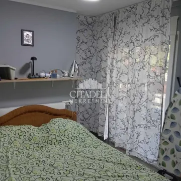 Spavaća soba sa bračnim krevetom i prozorom prekrivenim zavesama. - image 10