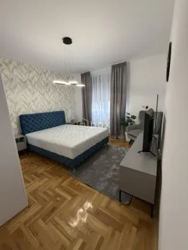 Nameštena spavaća soba sa bračnim krevetom, plakarom i televizorom. - image 9