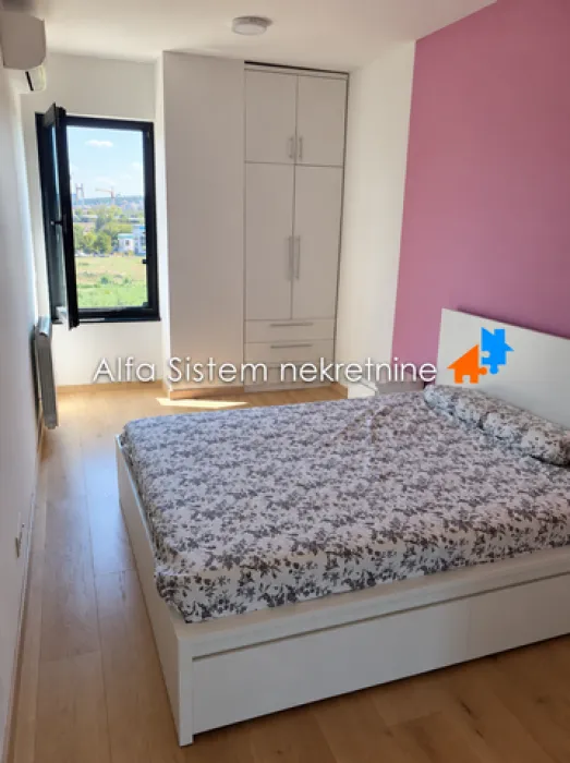 Spavaća soba sa bračnim krevetom, plakarom i prozorom.
