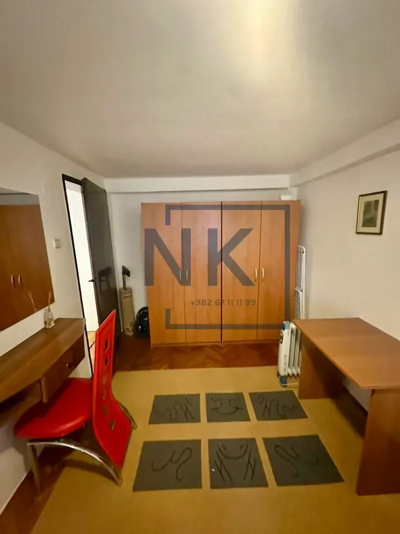 Bedroom with a wooden wardrobe, desk, and vanity table.