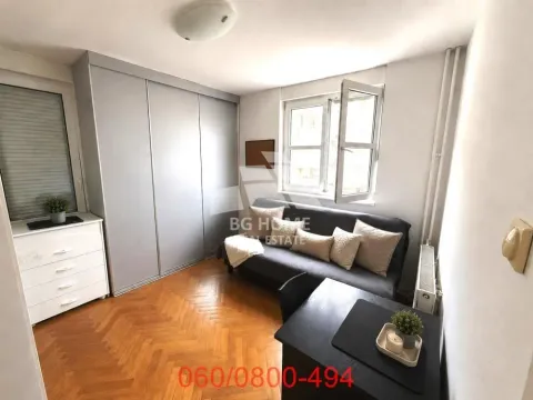 Small room with a sofa, wardrobe, and desk. - image 4