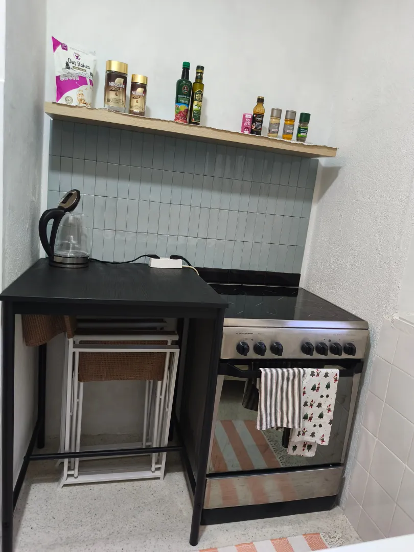 Manja kuhinja sa štednjakom i policom sa namirnicama.