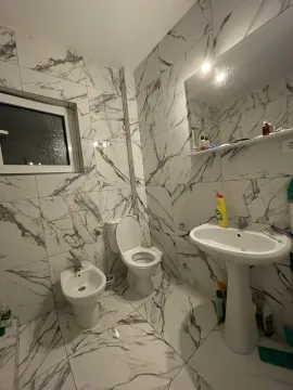 Kupatilo sa pločicama mermernog uzorka, lavaboom i toaletom. - image 19