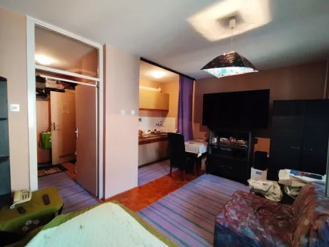 Dnevna soba sa televizorom, garniturom i pogledom na kuhinju u pozadini. - image 2
