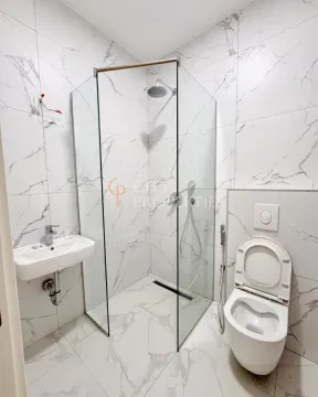 Modern bathroom with a glass-enclosed shower and marble-patterned tiles. - image 13