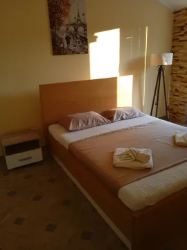 A tidy bedroom with a double bed and a wooden headboard. - image 5