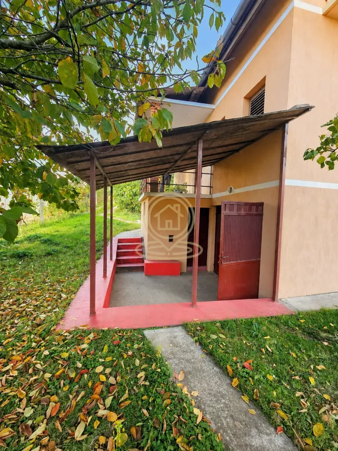 Spoljašnji pogled na dvorište i ulaz u kuću sa nadstrešnicom.
