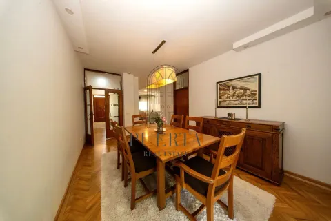 Spacious dining room with a wooden table, chairs, and sideboard. - image 5
