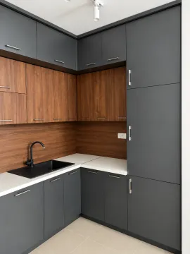 Modern corner kitchen with dark gray fronts and wood-toned elements. - image 7