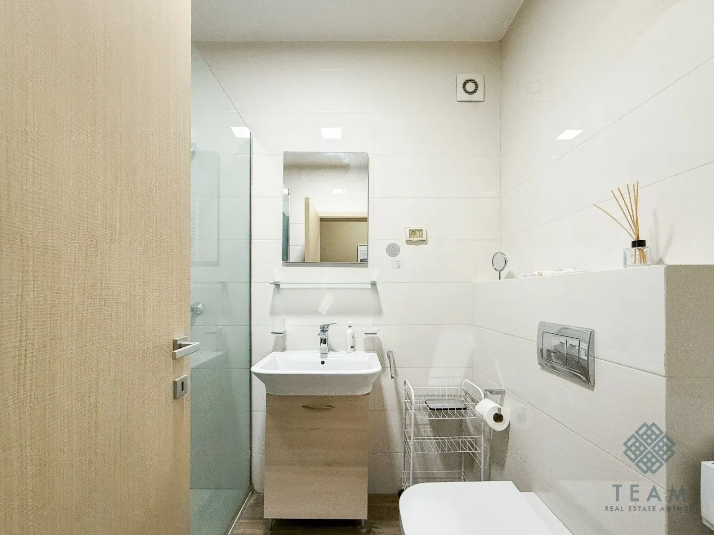 Smaller bathroom with a washbasin, shower cabin, and toilet.