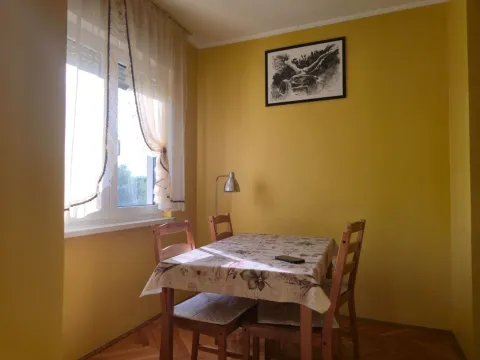 Dining area with a table, chairs, and a window against light walls. - image 5
