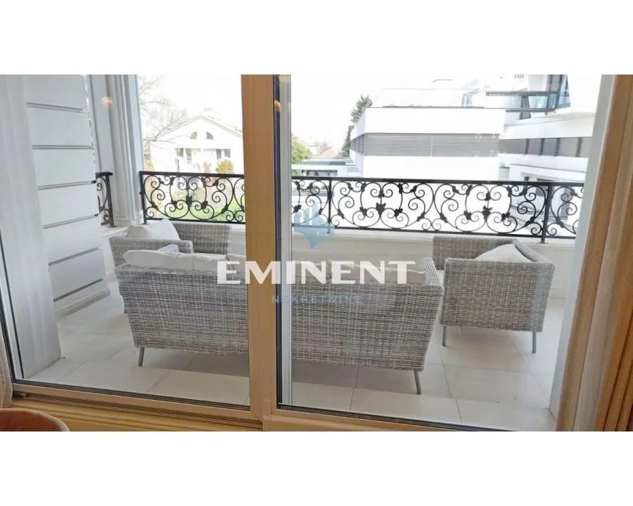 Natkriveni balkon sa garniturom za sedenje i pogledom na okolinu.