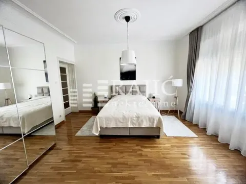 Spacious bedroom with a double bed, large mirror, and parquet flooring. - image 4