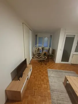 Dnevna soba sa drvenim podom, TV komodom i trpezarijskim stolom u pozadini. - image 5
