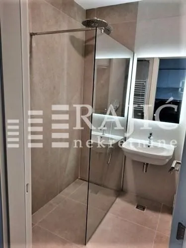 Modernly equipped bathroom with a walk-in shower and washbasin.