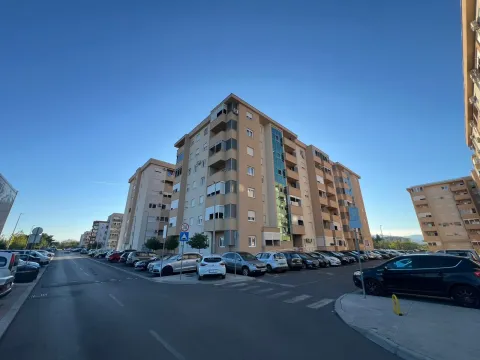 Pogled na višestambenu zgradu i okolni parking ispred ulaza. - image 9