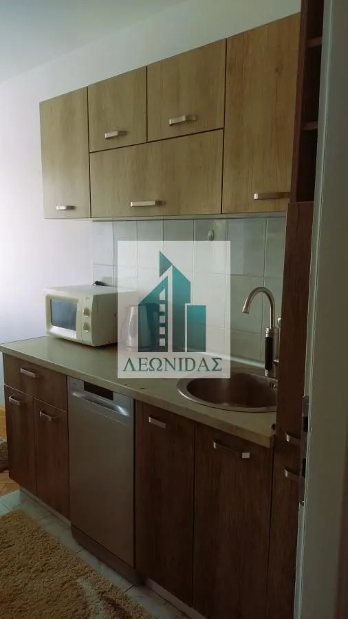 Smaller kitchen with wooden cabinets, sink, and built-in appliances.