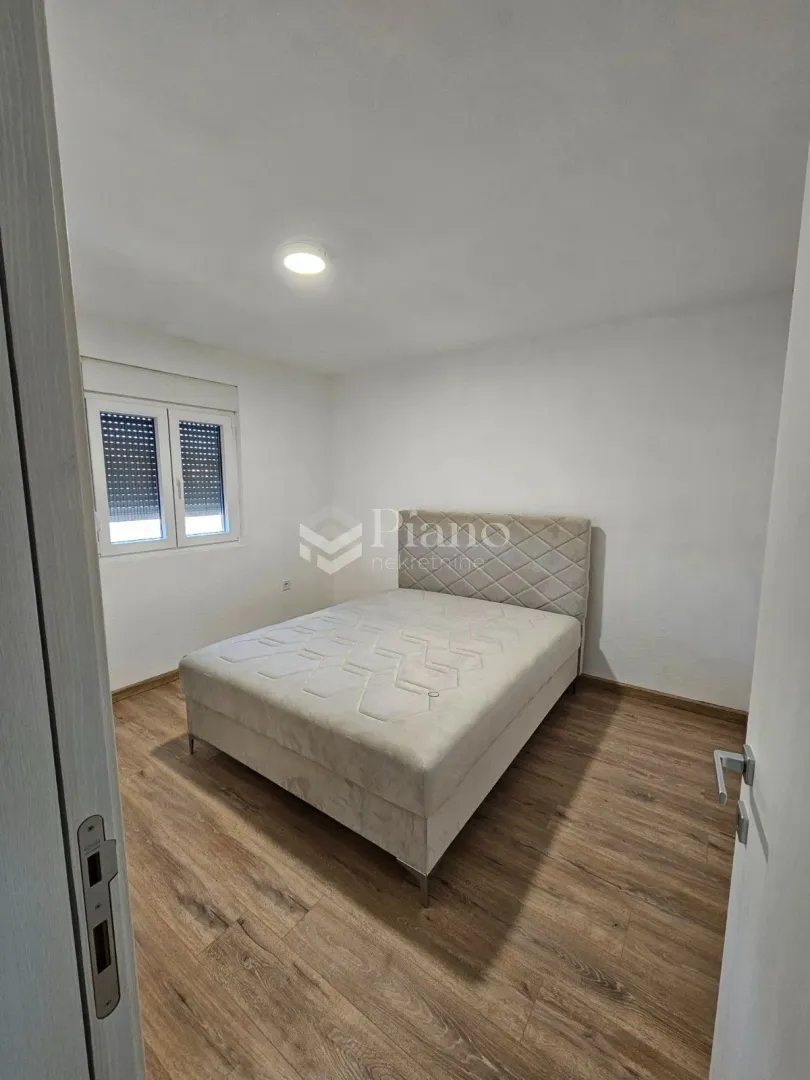 Bedroom with a double bed and wooden flooring.