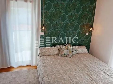 A decorated bedroom with a double bed and botanical-patterned wallpaper. - image 6