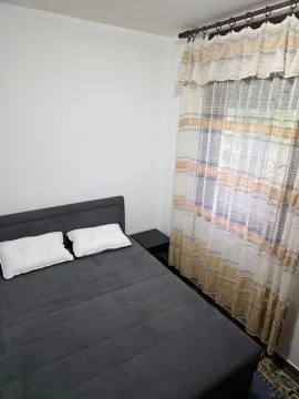 Spavaća soba sa bračnim krevetom i prozorom sa zavjesama. - image 3