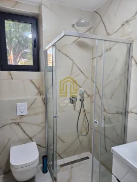 Moderne renovirano kupatilo sa tuš kabinom i mermernim pločicama. - image 8