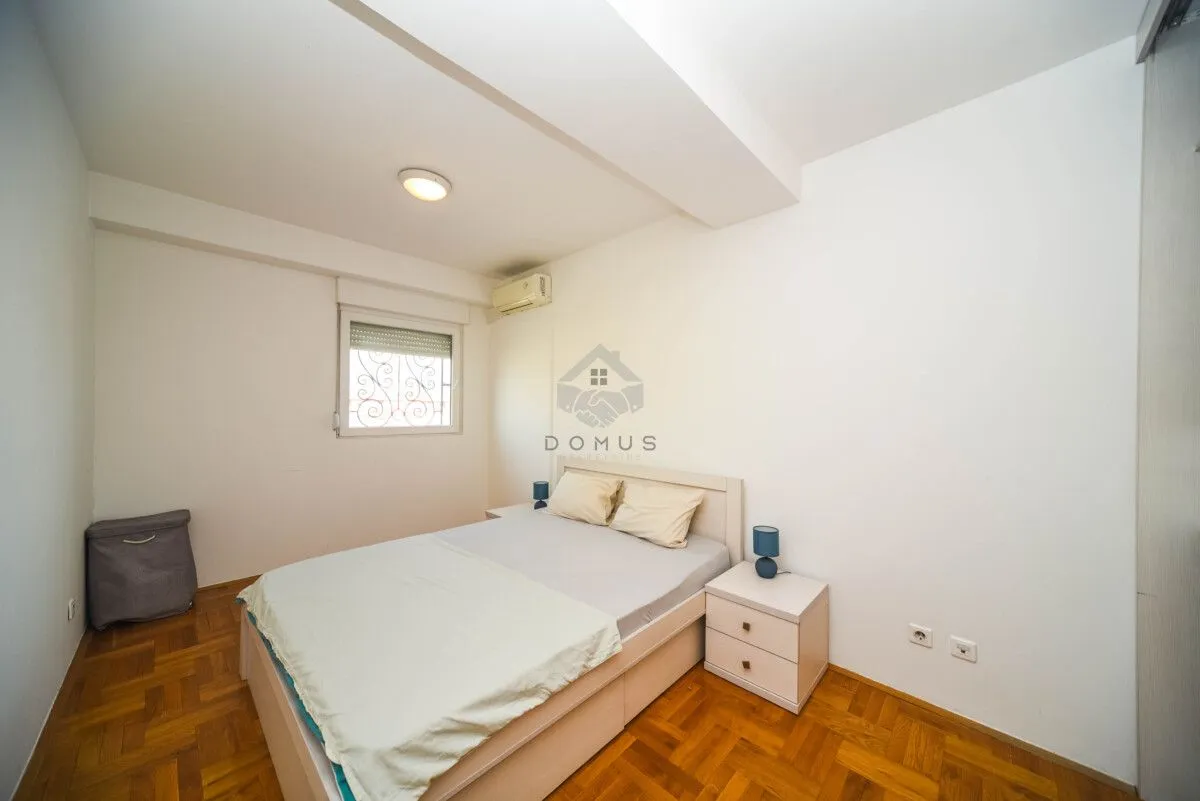 Smaller bedroom with a double bed, nightstands, and parquet flooring.