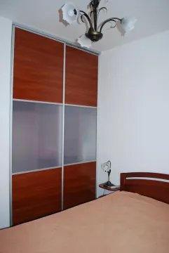 Bedroom with a large built-in wardrobe and a double bed. - image 3