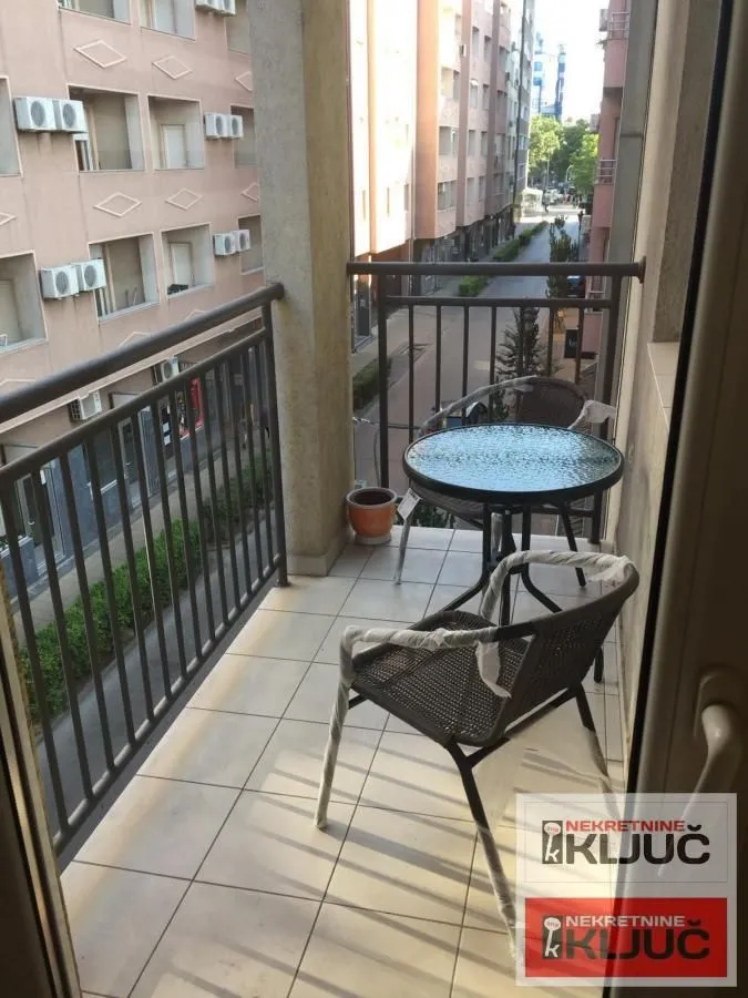 Manji namešteni balkoni sa stolom i stolicama i pogledom na ulicu.
