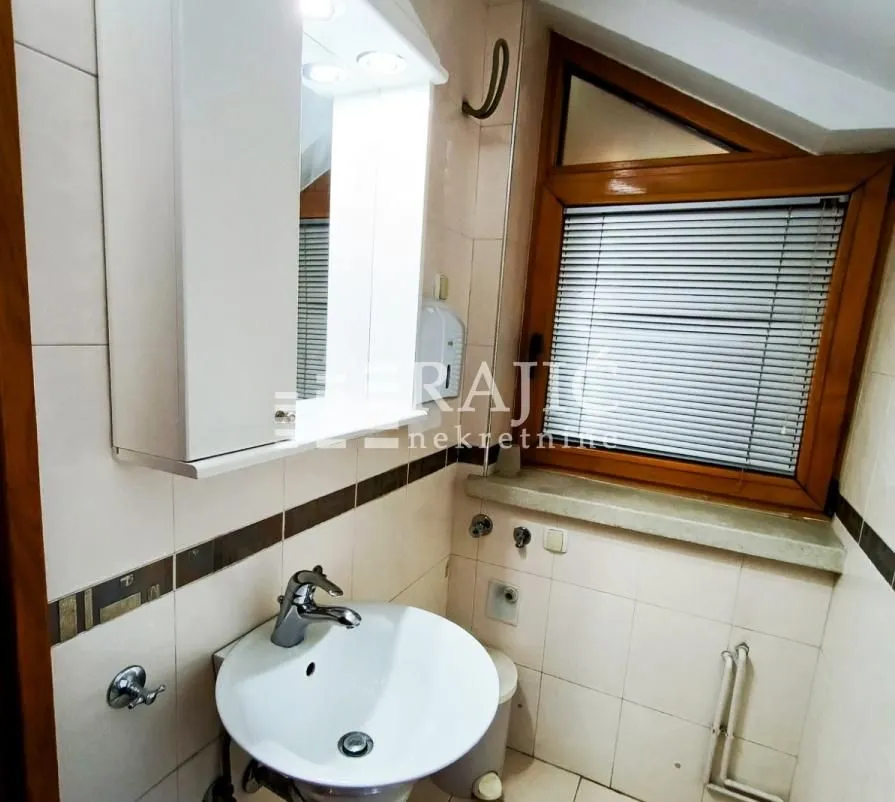 Smaller bathroom with a sink, mirror, and roof window.