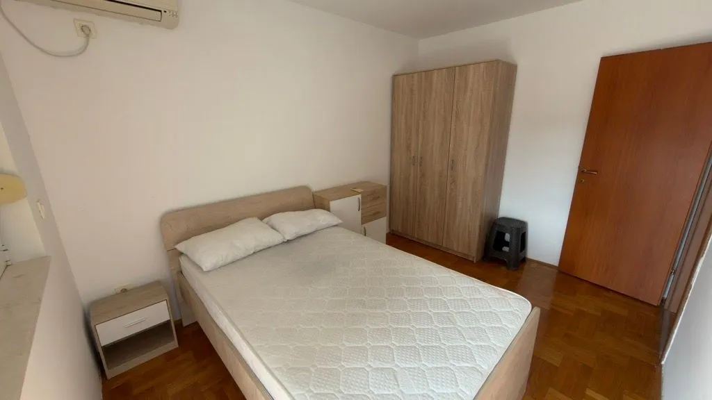 Furnished bedroom with a double bed, wardrobe, and nightstand.