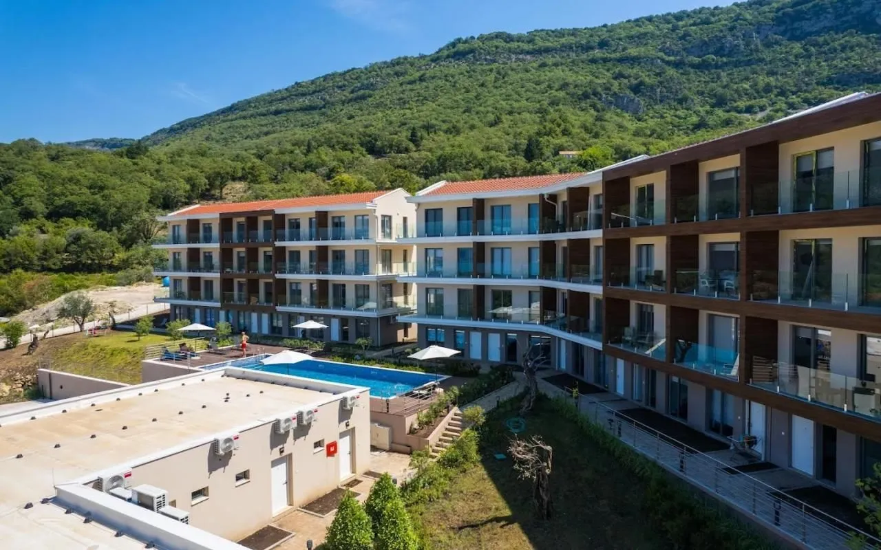Aerial view of a residential complex with a swimming pool surrounded by nature.