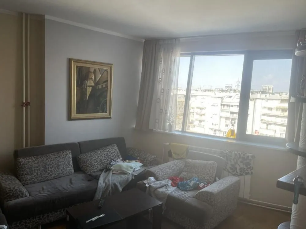 Living room with a sofa set and a large window.