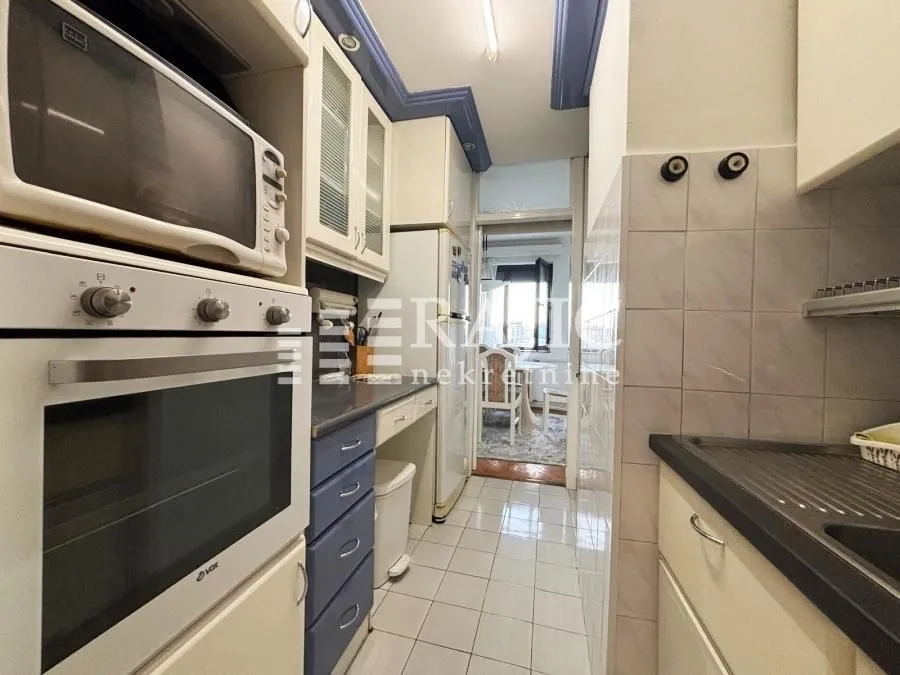 Smaller equipped kitchen with built-in units and appliances.
