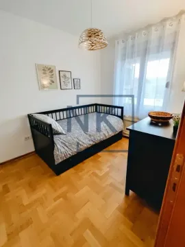 Manja spavaća soba sa krevetom i parketom na podu. - image 4