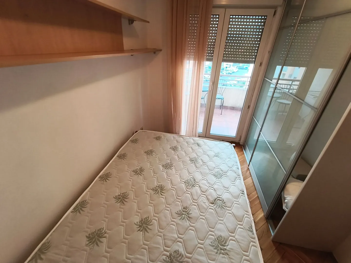 Small bedroom with a bed, wardrobe, and access to the terrace.