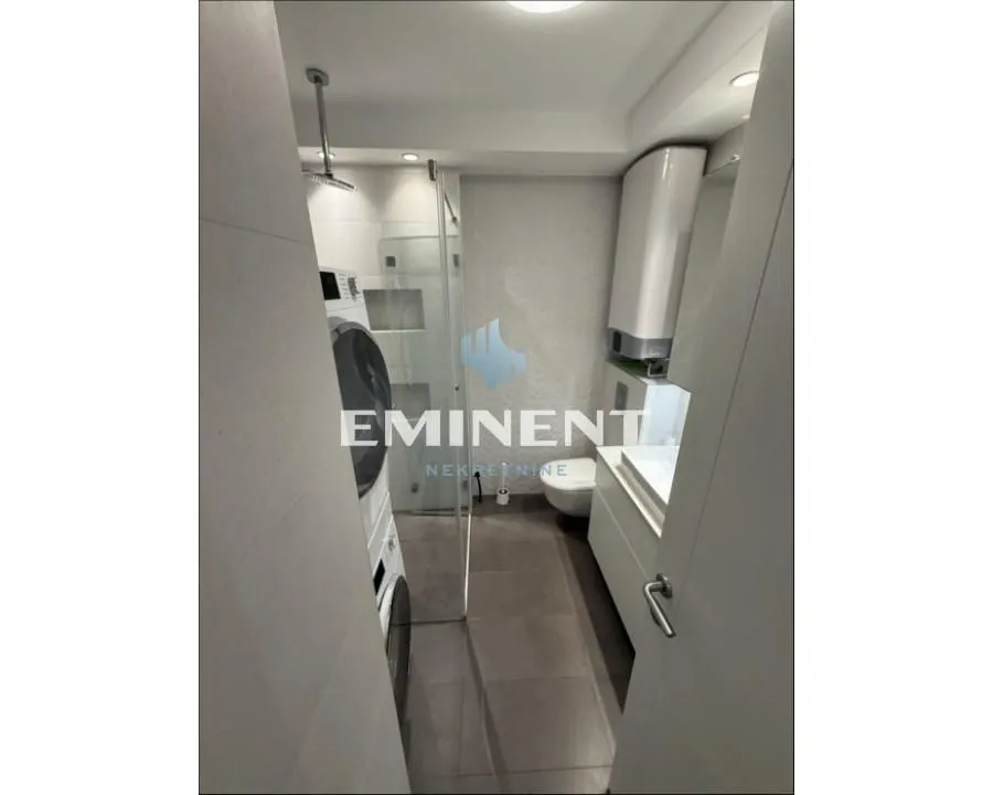 Modern bathroom equipped with a walk-in shower and a washing machine.
