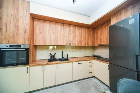 Kitchen with wooden cabinetry, built-in oven and black refrigerator. - image 5