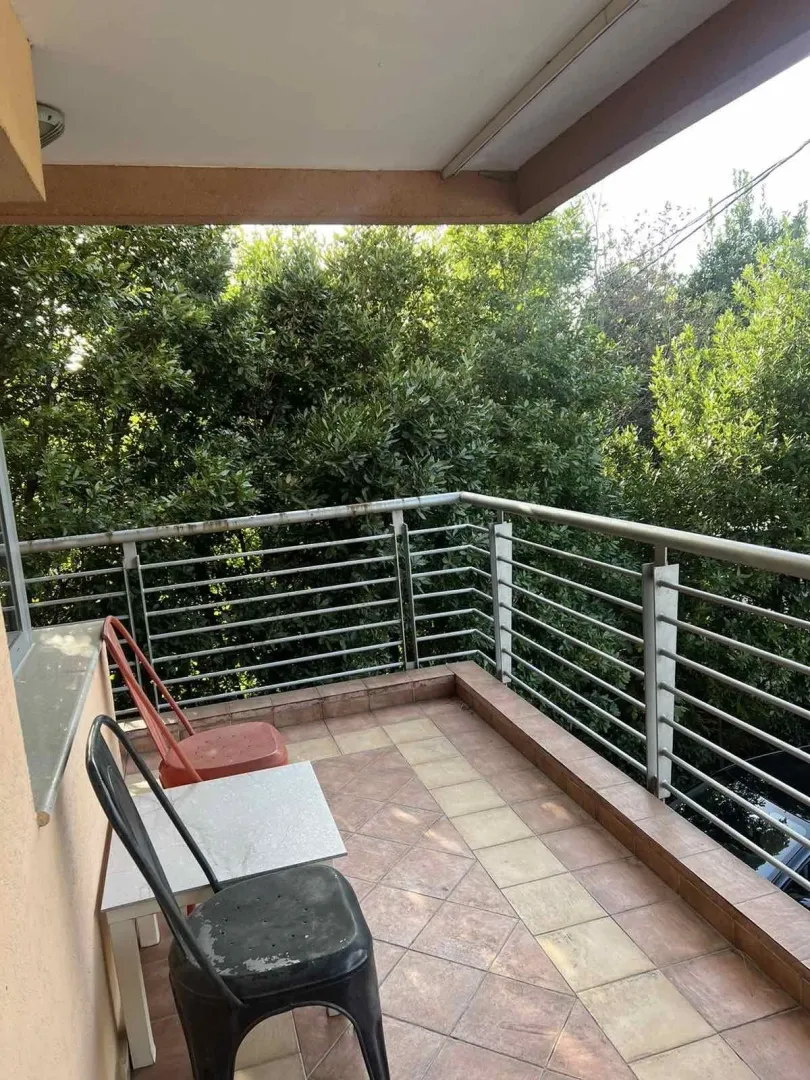 A spacious terrace with seating and a view of greenery.