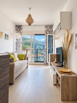 Bright living room with a sofa, TV unit, and access to the terrace. - image 3