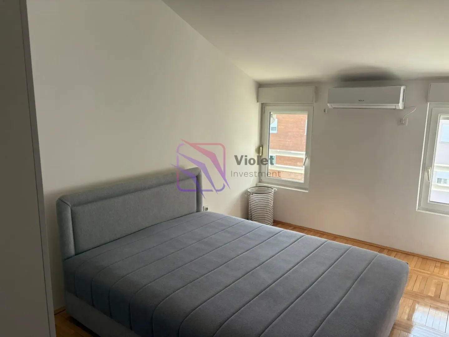 Bedroom with a double bed and an air conditioner.