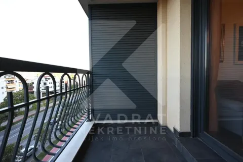 Natkriveni balkon sa metalnom ogradom i pogledom na ulicu. - image 11