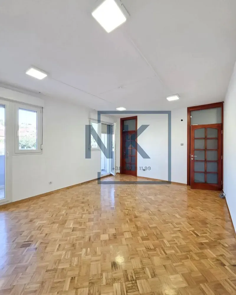 Empty room with parquet flooring and white walls.