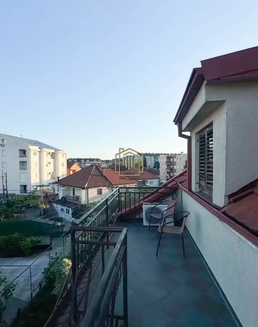 Prostrana terasa sa garniturom za sjedenje i pogledom na naselje.