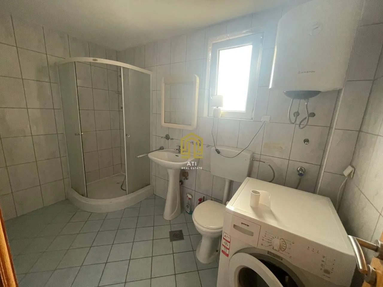 Kupatilo opremljeno sanitarijama, tuš kabinom i veš mašinom.