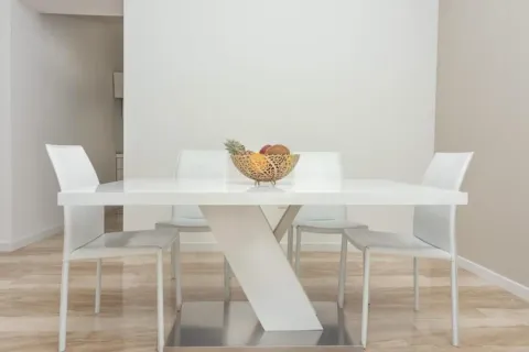 Dining area with a white table and chairs. - image 9