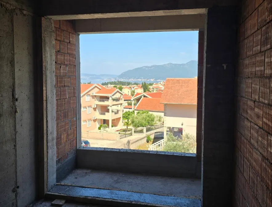 Pogled na more i naselje kroz prozor objekta u izgradnji.