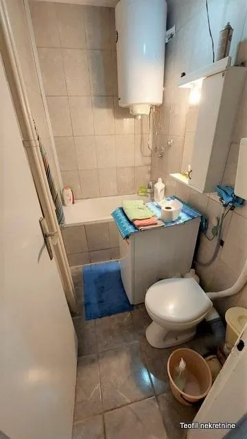 Smaller bathroom with a bathtub, toilet, and washing machine.