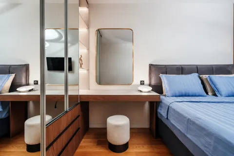 Modern bedroom with a double bed, built-in wardrobe, and vanity desk. - image 9
