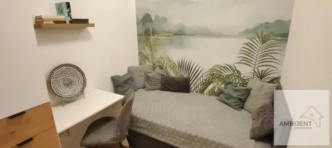 Smaller bedroom with a bed, a desk, and decorative wall wallpaper. - image 7