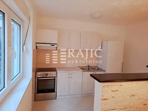 Small kitchen with wooden cabinets and white goods. - image 7